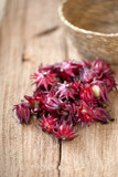 Fototapeta Lawenda - Roselle Hibiscus sabdariffa red fruit flower on wooden background. used for making tea or syrup. selective focus.