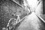 Fototapeta Uliczki - bicycle leaning against the wall on the background of the street