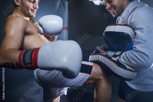 Foto Two athletes training kicks in the gym