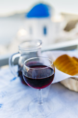 Wall Mural - Red greek wine and picturesque view of Old Town of Oia on the island Santorini.