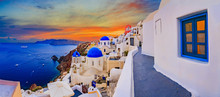 Amazing Wide Panorama Sunset View With White Houses On Church With Blue Roofs In Oia Village On Santorini Island In Greece.