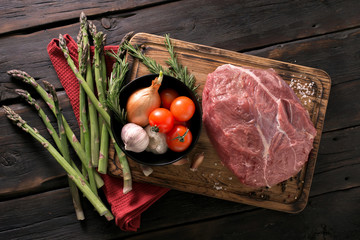 Wall Mural - Beef tenderloin with vegetables on kitchen board close up