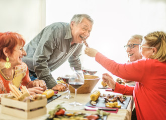 Happy senior friends having barbecue lunch at home