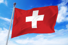 Flag Of Switzerland Developing Against A Clear Blue Sky