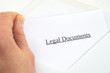 Legal Documents printed on white paper and envelope, hand holding it, white background
