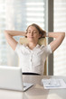 © fizkes - Satisfied businesswoman leaning back in chair and relaxing at the desk with hands behind head. Lady dreaming about business success with closed eyes. Short break during hard work day