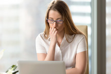 Young Woman Attentively Looking On Laptop Screen At Office. Businesswoman Mulling Decision Of Problem. Female Entrepreneur Ponders An Answer On E-mail. Thoughtful Office Worker Doubts About Results