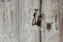 Padlock And Handle On Grungy Old Wooden Door With Hardly Any Paint Left
