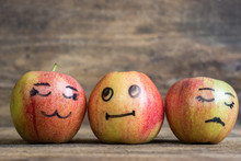 Face On An Apples. Apple Family On Wooden Background. Room For Text 