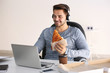 © Africa Studio - Young handsome man having a break and eating tasty pizza at office