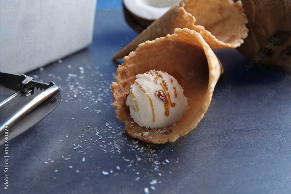 Fresh coconut ice cream in wafer cone on table