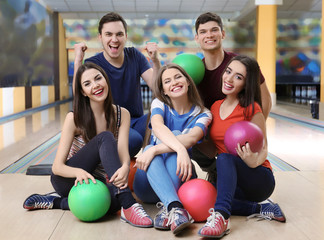 Wall Mural - Friends sitting on floor in bowling club