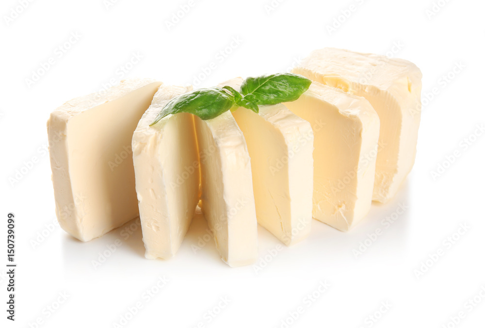Delicious butter pieces with basil leaves on white background, closeup