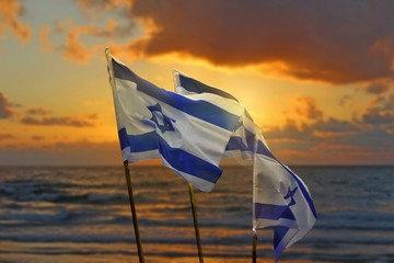 Three flags of Israel on the coast of Mediterranean sea.