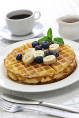 Wall Mural - homemade american round waffles with blueberry and banana pouring maple syrup
