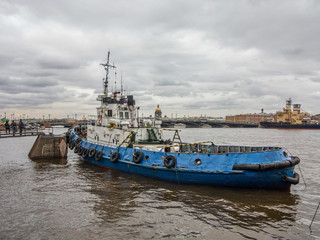 A small blue boat on the background of the panorama of St. Petersburg