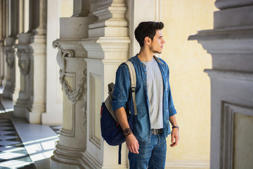 Half Body Shot of a Thoughtful Handsome Young Man, Looking Away Inside a Museum