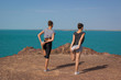 © polinabelphoto - Two girls are doing yoga meditation on the beach. The concept of sports and healthy lifestyle. Summer holidays