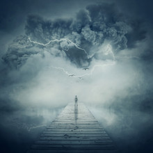Fantastic View As A Man, Stand On The Wooden Pier At The Middle Of The Lake In A Foggy And Stormy Day Watching A Hurricane Coming. Facing The Life Pressure And Stress Concept.