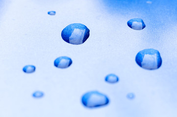 Water drops on gradient of twinkling blue and white background surface or texture