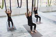 © Kateryna Muzhevska - Young women doing aerial yoga exercise