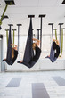 © Kateryna Muzhevska - Young women doing aerial yoga exercise