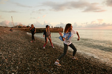 Girls Throwing Stones In The Water At The Pierce