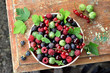 Garden berries in a bowl on wooden table