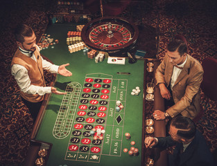 Wall Mural - Upper class friends gambling in a casino