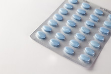 Blue Oval Pills In Blister Package On White Close Up