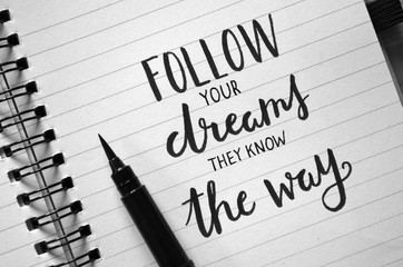 Wall Mural - FOLLOW YOUR DREAMS THEY KNOW THE WAY inspirational quote written in notebook