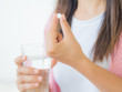 © Siam - medicine, health care and people concept - close up of woman taking in pill