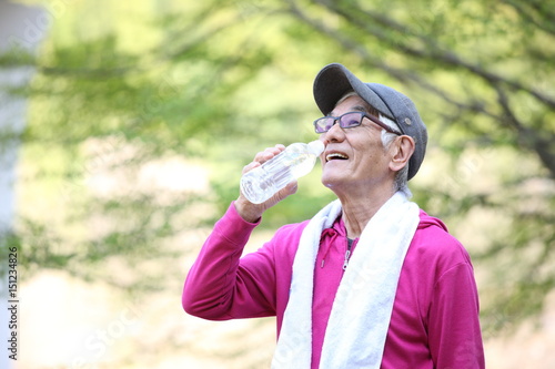 屋外での運動の合間にペットボトルの水を飲むシニアの男性 Stock Photo Adobe Stock