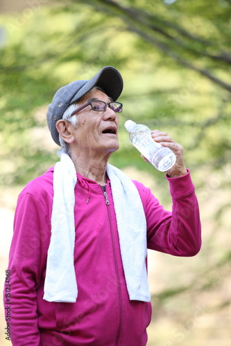 屋外での運動の合間にペットボトルの水を飲むシニアの男性 Stock Photo Adobe Stock