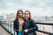 © Elena Kratovich - couple of women together in cityscape . Two joyful beautiful fashionable girls on roof . Beautiful city view