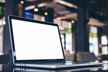 mockup image of laptop with blank white screen on wooden table in coffee shop