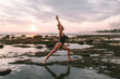 © ArinaEmelyanova - Attractive red hair woman practicing yoga on the coast of Indian ocean in a black swimsuit during sunset, Indonesia, Bali