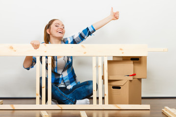 Wall Mural - Woman moving into apartment assembly furniture.