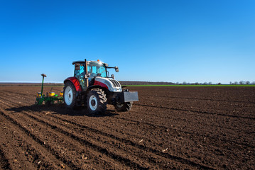 Aufkleber - Agriculture tractor sowing seeds and cultivating field. Blue sky!