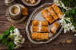 Homemade baklava rolls in iron try on wooden background. Ramadan food. Selective focus
