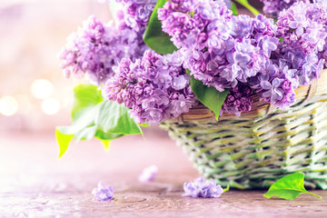 Sticker - Lilac flowers bunch in a basket over blurred wood background