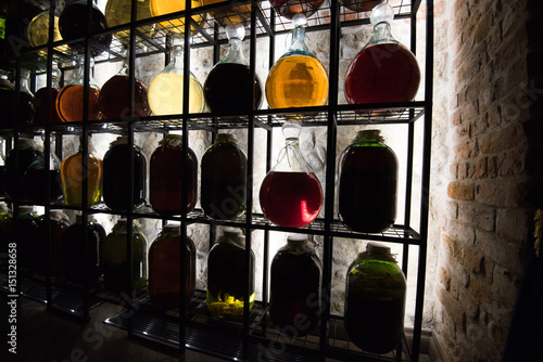 Alcohol In Vintage Large Bottles Is Placed On Decorative Racks