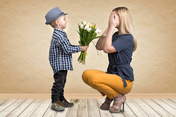small son gives his beloved mother a bouquet of beautiful tulips. spring, concept of family vacation