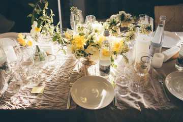 Wall Mural - Wedding banquet at sunset. Table for guests, decorated with candles and flowers, served with cutlery and crockery and covered with a tablecloth. Table decorated for the wedding reception