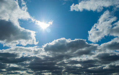 Wall Mural - Bright Sunburst in Blue Cloudy Sky overlay