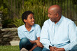 © digitalskillet1 - African American father and son talking and laughing.
