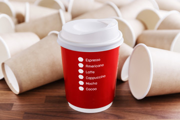 Wall Mural - red paper coffee cup with brown paper cups background