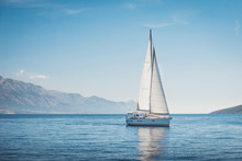 Sailing Yacht In The Sea Against The Backdrop Of Mountains