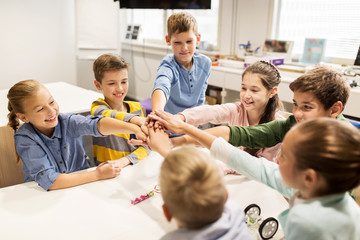 Wall Mural - happy children holding hands at robotics school