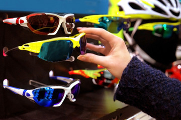 Poster - Young woman selecting new glasses in shop